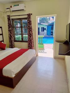 a bedroom with a bed and a view of a pool at JV HOLIDAY HOME CANDOLIM in Candolim