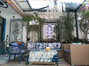 a living room with blue and white furniture and a chandelier at Dali Favorite Inn in Dali