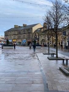 a city square with buildings and people walking around at No 10, St James Street, Burnley in Burnley