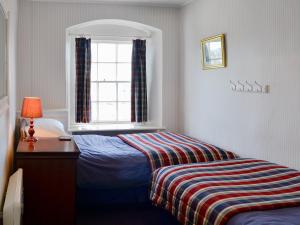 een kleine slaapkamer met een bed en een raam bij Hornblower - Hddv in Ilfracombe