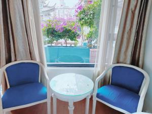 two chairs and a table in front of a window at Dali Favorite Inn in Dali