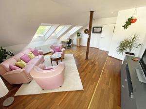 a living room with a pink couch and chairs at Ferien am Königshof in Georgsmarienhütte