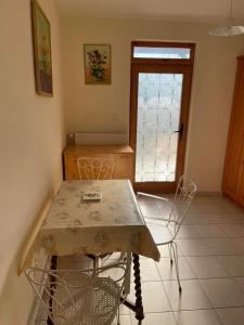 a table and chairs in a room with a door at Csuka Vendégház in Kisbodak