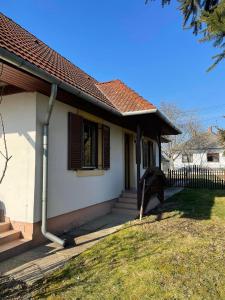 una pequeña casa blanca con valla y escaleras en Csuka Vendégház, en Kisbodak