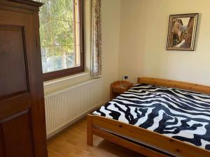 Dormitorio con cama con estampado de cebra en una habitación en Csuka Vendégház, en Kisbodak