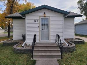 ein kleines weißes Haus mit einer Treppe, die zu einer Tür führt in der Unterkunft Cozy 2 bedroom West Fargo home with 2 car garage in West Fargo
