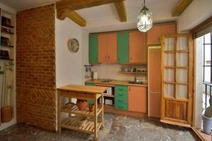 una cucina con armadi colorati e un muro di mattoni di Frente a la Alhambra a Granada