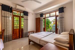 a bedroom with a bed and a large window at Royal Villa in Weligama