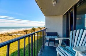 a balcony with two chairs and a view of the beach at 0305 Mako Your Dreams Come True by Atlantic Towers in Carolina Beach