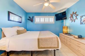 a blue bedroom with a bed and a flat screen tv at 0305 Mako Your Dreams Come True by Atlantic Towers in Carolina Beach