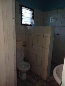 baño con aseo y ventana en Moha Airbnb Diani en Ukunda
