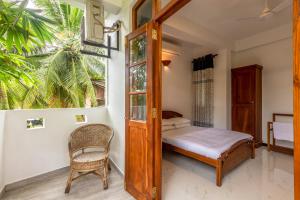 a bedroom with a bed and a window and a chair at Royal Villa in Weligama