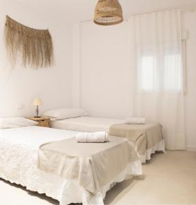 2 Betten in einem weißen Zimmer mit weißen Wänden in der Unterkunft Nuevo apartamento planta baja in Bellreguart