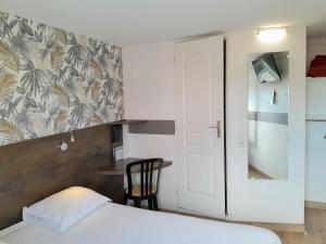 a bedroom with a bed and a desk with a chair at Fasthotel Narbonne in Narbonne
