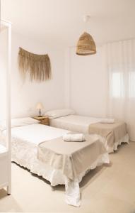 zwei Betten in einem Zimmer mit weißen Wänden in der Unterkunft Nuevo apartamento planta baja in Bellreguart