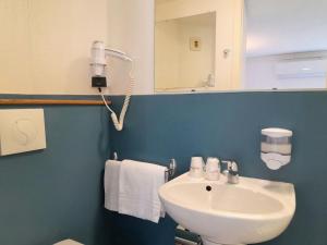 W łazience znajduje się biała umywalka i lustro. w obiekcie Fasthotel Narbonne w mieście Narbona