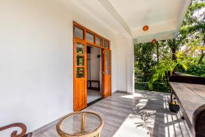 a porch with a wooden door and a table and chairs at Royal Villa in Weligama