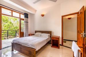 a bedroom with a bed and a large window at Royal Villa in Weligama