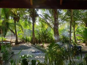 a view from a window of a jungle with palm trees at Gems Garden Guest House in Tangalle
