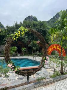 a swimming pool with a bench with flowers around it at Tam Coc Valley Homestay in Ninh Binh