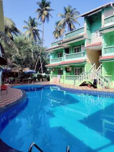 a swimming pool in front of a hotel at JV HOLIDAY HOME CANDOLIM in Candolim