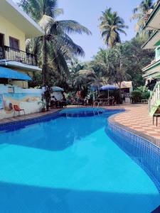 a large blue swimming pool next to a resort at JV HOLIDAY HOME CANDOLIM in Candolim