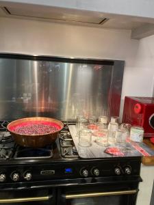 a pan of food on a stove in a kitchen at Les chambres d'Agath'ânes in Ganac