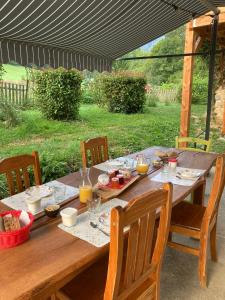 einen Holztisch mit Essen darüber in der Unterkunft Les chambres d'Agath'ânes in Ganac