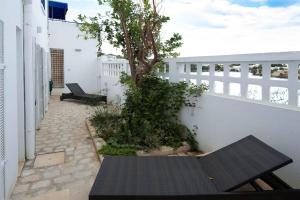 uma mesa preta e uma árvore numa varanda em "L'Abri Côtier" Appartement 3 chambres Haut Standing Port Punique Carthage em Douar ech Chott