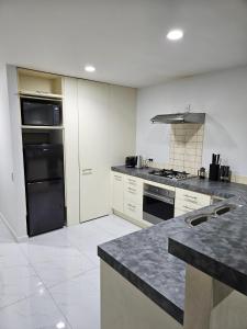 a kitchen with a black refrigerator and a stove at Spacious and Luxury, City Fringe Bliss! in Wellington