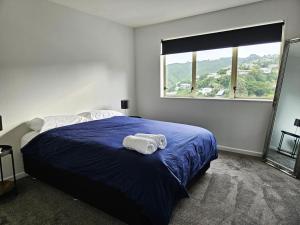 a bedroom with a bed with two towels on it at Spacious and Luxury, City Fringe Bliss! in Wellington