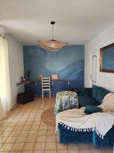 ein Wohnzimmer mit einem blauen Sofa und einem Tisch in der Unterkunft La petite Maison de La Saline-les-Bains in Saint-Paul