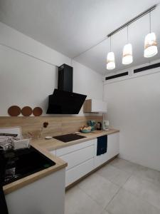 eine Küche mit weißen Schränken und einer Arbeitsplatte in der Unterkunft La petite Maison de La Saline-les-Bains in Saint-Paul