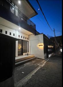 a white building with a balcony on a street at Cahaya Residence The Guest House in Kuta