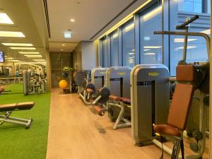 a gym with a row of treadms and machines at HomesGetaway-Lovely STU in Hyatt Regency Creek Heights Residences in Dubai
