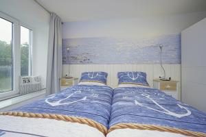 1 dormitorio con 1 cama con una pintura en la pared en TRAUM FeWo Strandliebe mit Meerblick, 3 Schlafzimmer, 2 Bäder, en Binz