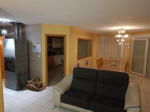 a living room with a couch and a kitchen at Le plein soleil in Cornimont