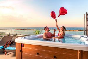 2 Personen sitzen in einer Whirlpool-Badewanne in der Unterkunft You & Me Beach Hotel in Rimini