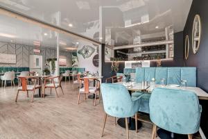 a restaurant with wooden tables and blue chairs at Location Au Sommet du Lac Magog in Magog-Orford