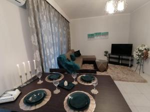 a living room with a table with plates and wine glasses at DZ Apartment AXD in Alexandroupoli