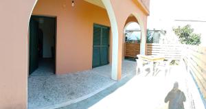 a cat sitting on the outside of a house at Pitsinis Apartments I in Roda