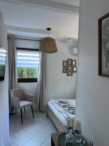 een slaapkamer met een bed, een stoel en een raam bij LE MAS RESCATOR in Vence