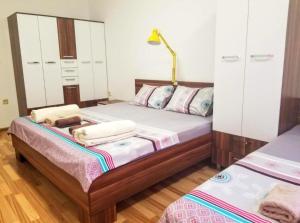 a bedroom with two beds with white cabinets at Sky Apartments in Strumica