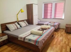 1 dormitorio con 2 camas y lámpara. en Sky Apartments, en Strumica