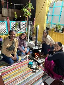 Black Pepper Home Stay في أودايبور: مجموعة من النساء جالسات على الأرض