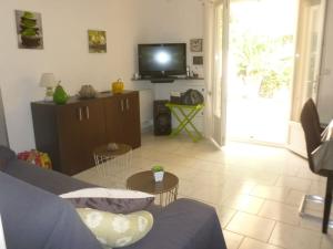 a living room with a blue couch and a tv at Villa SYMPHONY A PIANA CORSE DU SUD in Piana