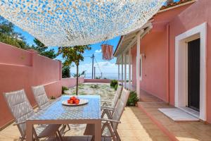 a table and chairs on the balcony of a house at Villa Aelios in Patitiri