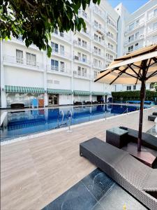 a hotel swimming pool with a table and an umbrella at Country Inn & Suites By Migrolino in Lucknow