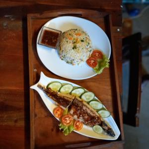 due piatti di cibo su un vassoio di legno di La-Vira Beach Villa a Hikkaduwa