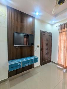 een woonkamer met een tv en een blauw aquarium bij Capital Lodges in Gujrānwāla